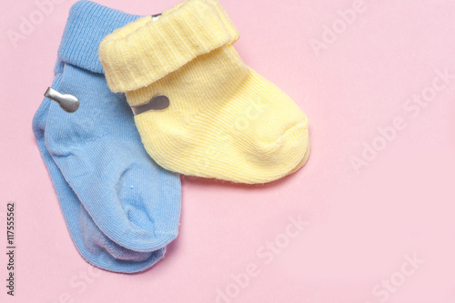 Cotton baby socks for newborn on a colorful pink background. Copy space for text. Top view