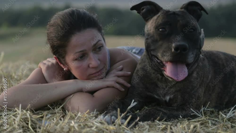 Young woman with a dog in the manger. Portrait of a girl in a field with a terrier.
Young woman with a dog in the manger. Portrait of a girl in a field with a terrier.