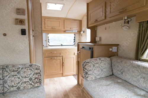 Inside a caravan showing seats and kitchen area