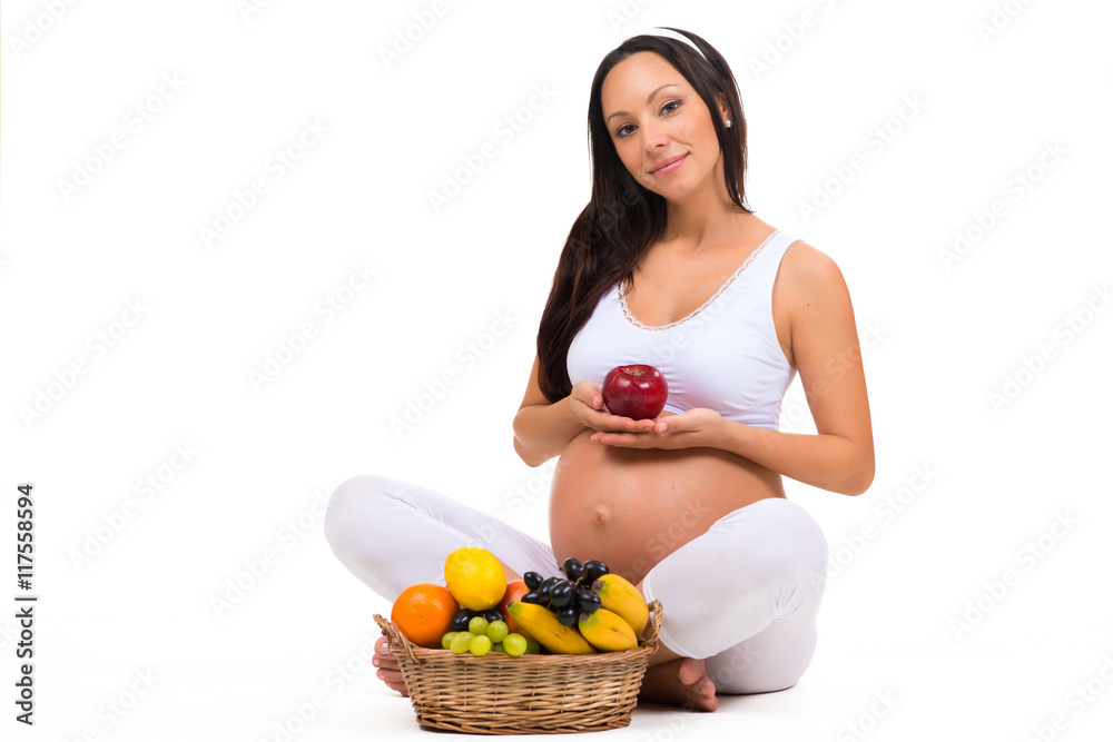 Vitamins and proper nutrition during pregnancy. Pregnant women with apple and basket of fruit Vitamins and proper nutrition during pregnancy. Pregnant women with apple and basket of fruit