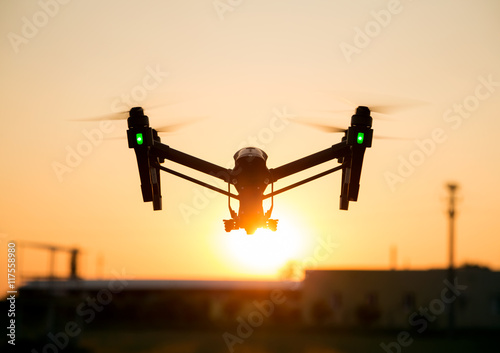 Professional drone flying in the sunset with orange sky