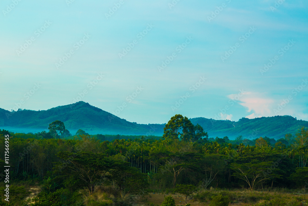 Fototapeta premium Misty morning sunrise of hilly area with ray of light.