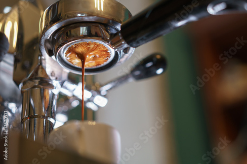 Fotografia espresso pouring from bottomless portafilter