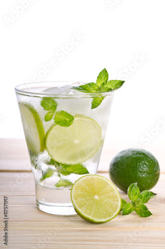 Mojito cocktail with lime on wooden table