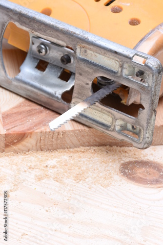 Electric jigsaw with wooden board close up