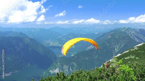 Austria, Obertraun, near 5 Fingers. Paraglider kicks and flying over the mountains, Hallstatter See and settlements. UHD