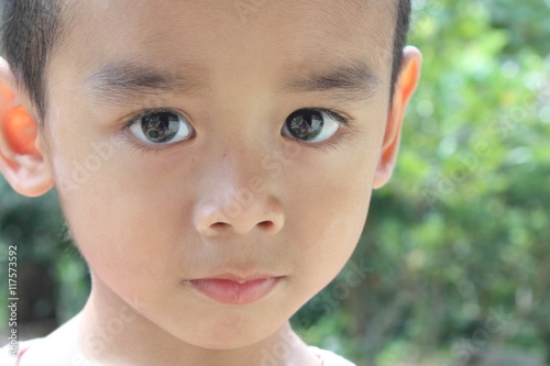 Little boy face and big eyes in countryside looking at the camera  selective focus