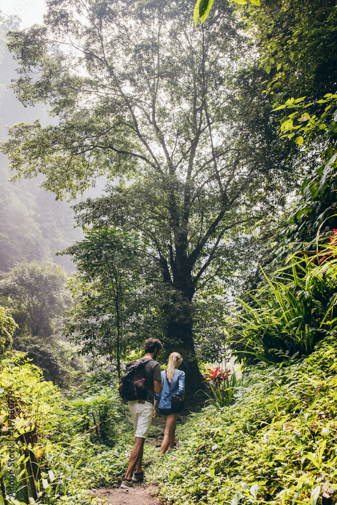 Obraz premium Couple of tourists walking along the forest trail