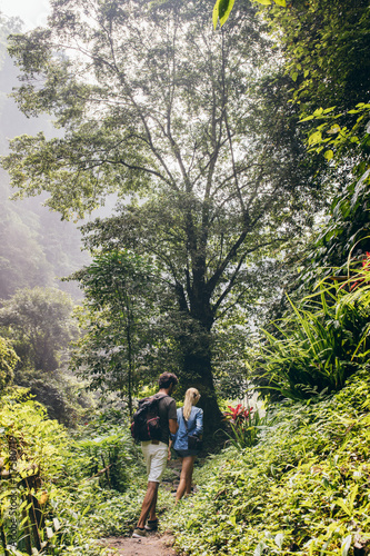 Couple of tourists walking along the forest trail