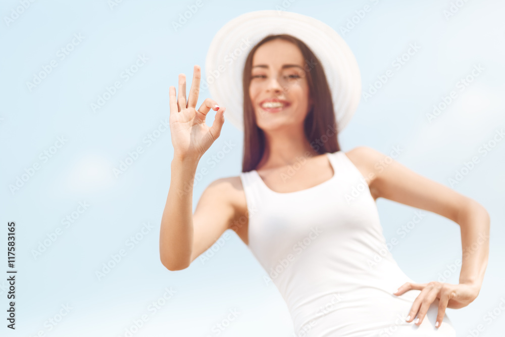 Beautiful young woman showing gesture ok. Summer holidays and vacation concept. Beautiful young woman showing gesture ok. Summer holidays and vacation concept.