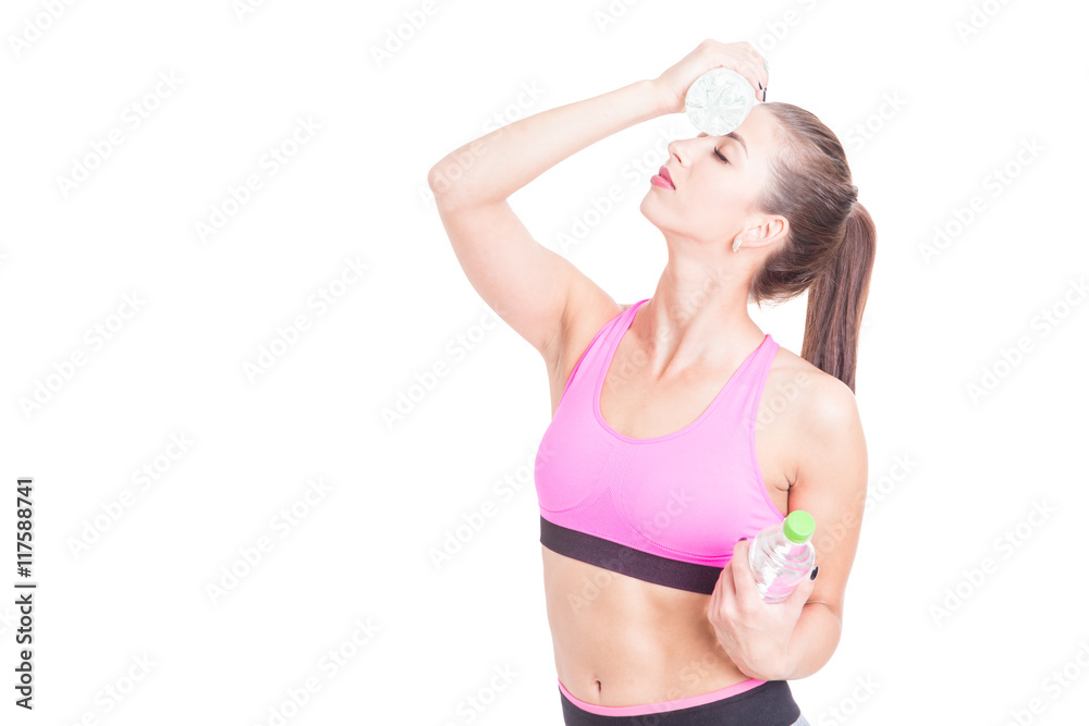 Young female at gym refreshing with water bottle
