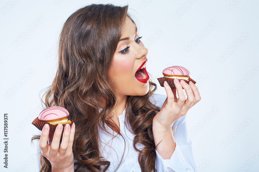 Young woman bites cake. Close up portrait of beautiful woman Young woman bites cake. Close up portrait of beautiful woman