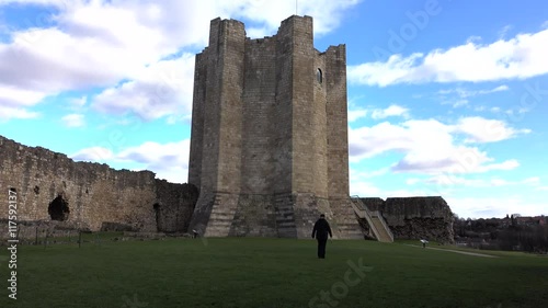 Conisbrough Castle England woman in courtyard. Medieval fortification built in the 11th century. Maintained by English Heritage as a historical landmark,  Ancient Monument and education. photo