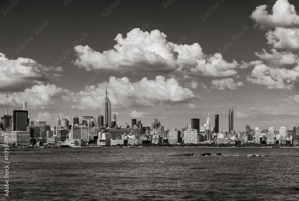 Manhattan Midtown West skyscrapers and Hudson River with passing clouds in Black & White. Cityscape of a summer afternoon in New York City with view of Midtown and West Village 