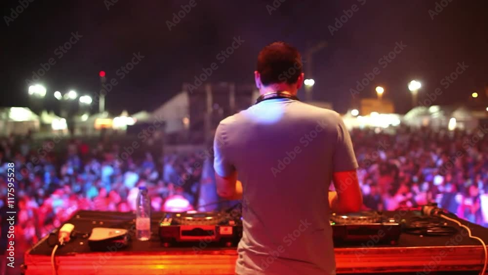 dj at a music event from behind dj at a music event from behind