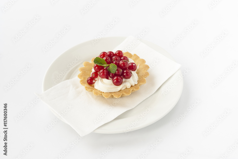 Delicious mini tart with fresh red currants and cream on white plate. Delicious mini tart with fresh red currants and cream on white plate.