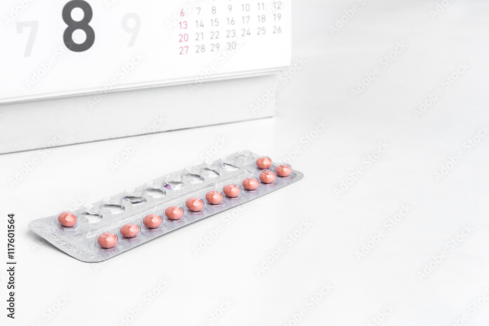 Close up birth-control pill with date of calendar background, health care and medicine concept Close up birth-control pill with date of calendar background, health care and medicine concept