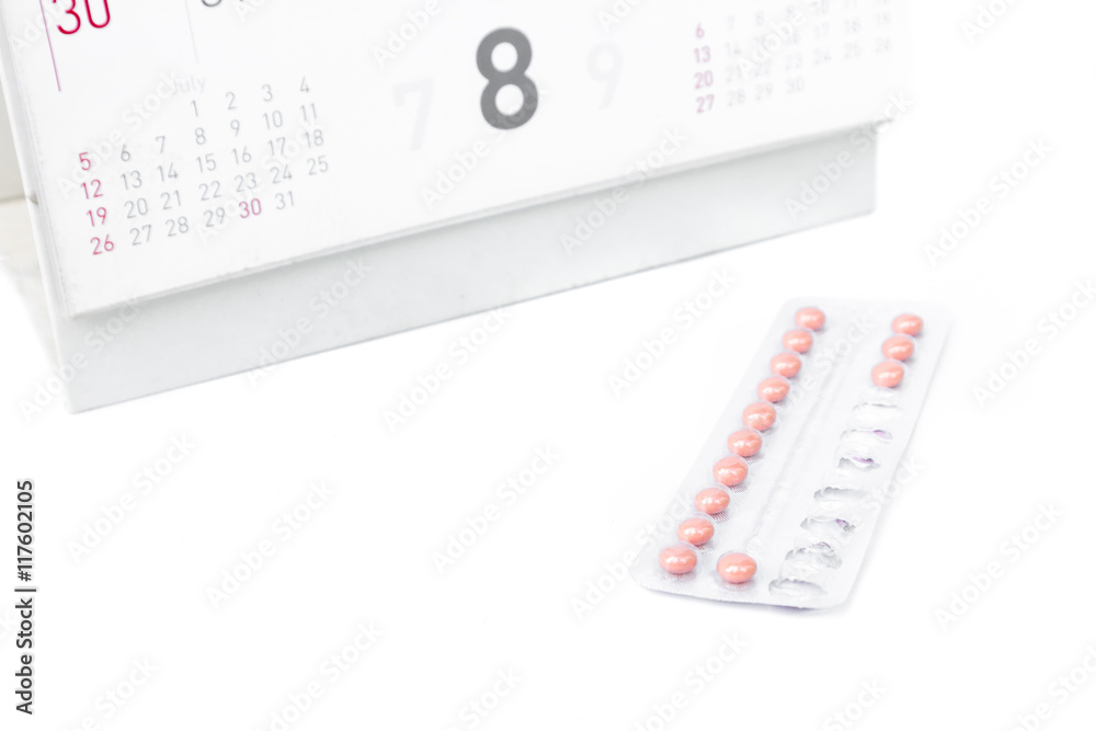 Close up birth-control pill with date of calendar background, health care and medicine concept Close up birth-control pill with date of calendar background, health care and medicine concept