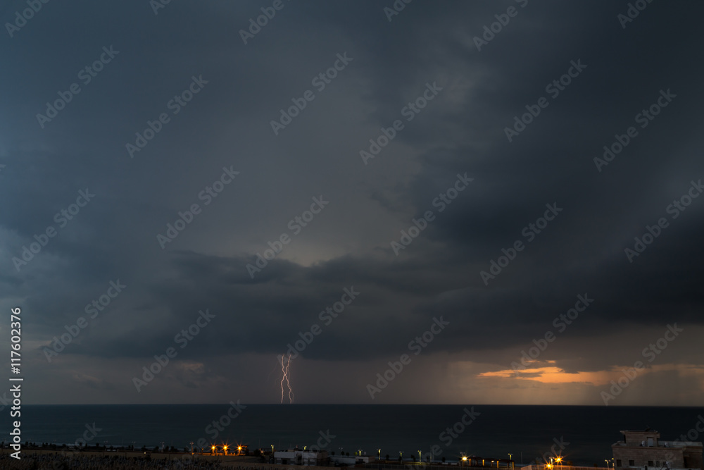 Lightning storm over the cemetery and sea of Nahariya during sunset