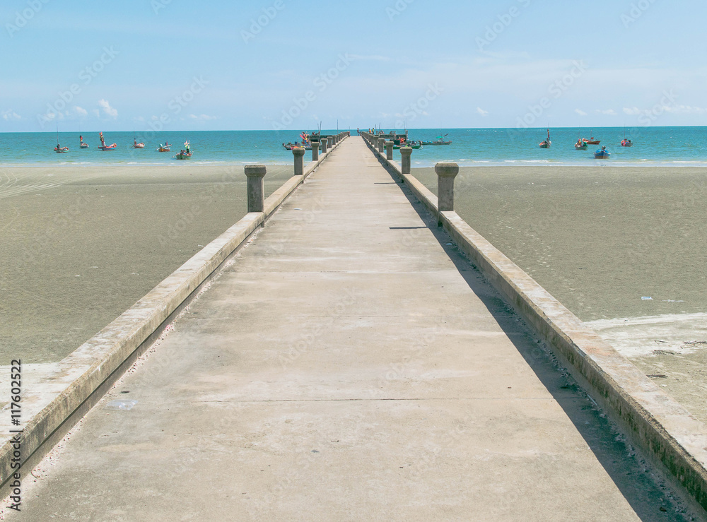 Bridge stone on the beach and sea with blue sky.