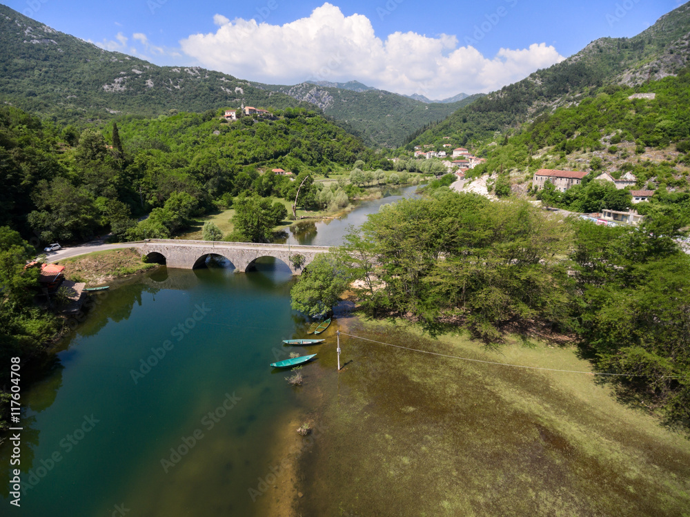 Small town is on river Crnojevica with arch bridge across. National park in Montenegro
