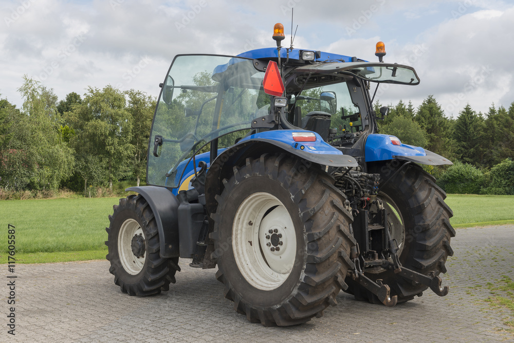 Modern blue tractor on a farmyard. Modern blue tractor on a farmyard.
