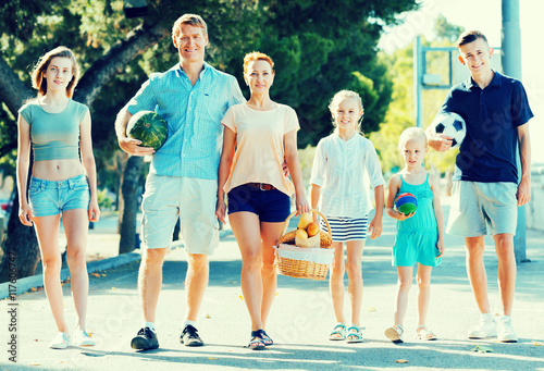 Man and woman with four kids smiling and taking walk