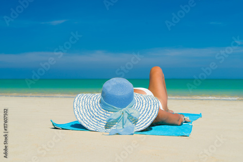 Fit woman in sun hat and bikini at beach