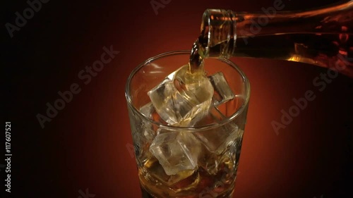 barman pouring whiskey in the glass on table with reflection, warm evening atmosphere,