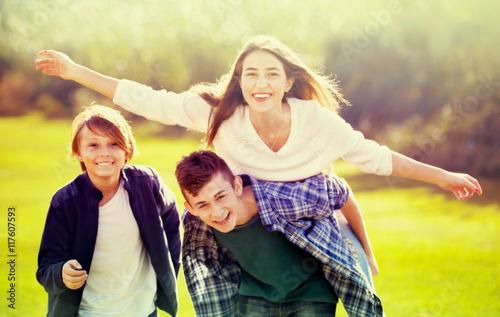 Girl with two boys posing in fall park