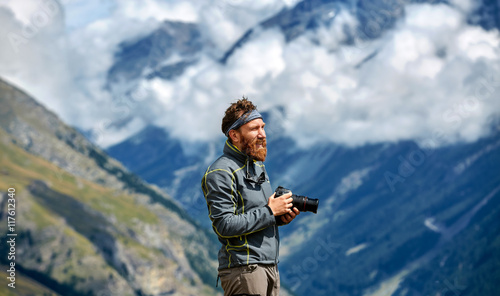 hiker at the top of a pass with camera enjoy sunny day in Alps. Switzerland, Trek near Matterhorn mount.