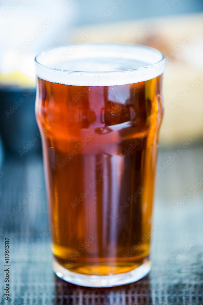 Pint of Bitter Beer in a Glass on a Table Setting Pint of Bitter Beer in a Glass on a Table Setting