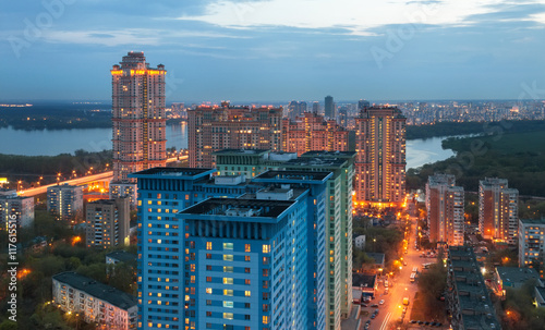 Widok z wysokości na wieżowiec na obrzeżach Moskwy w półmroku na tle rzeki