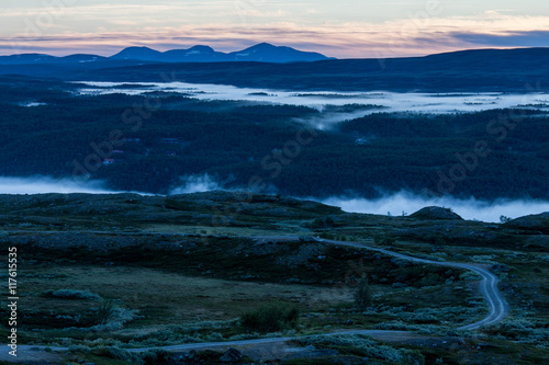 Sunrise in the Swedish mountains, very early during summertime. Morning mist down in the valley.