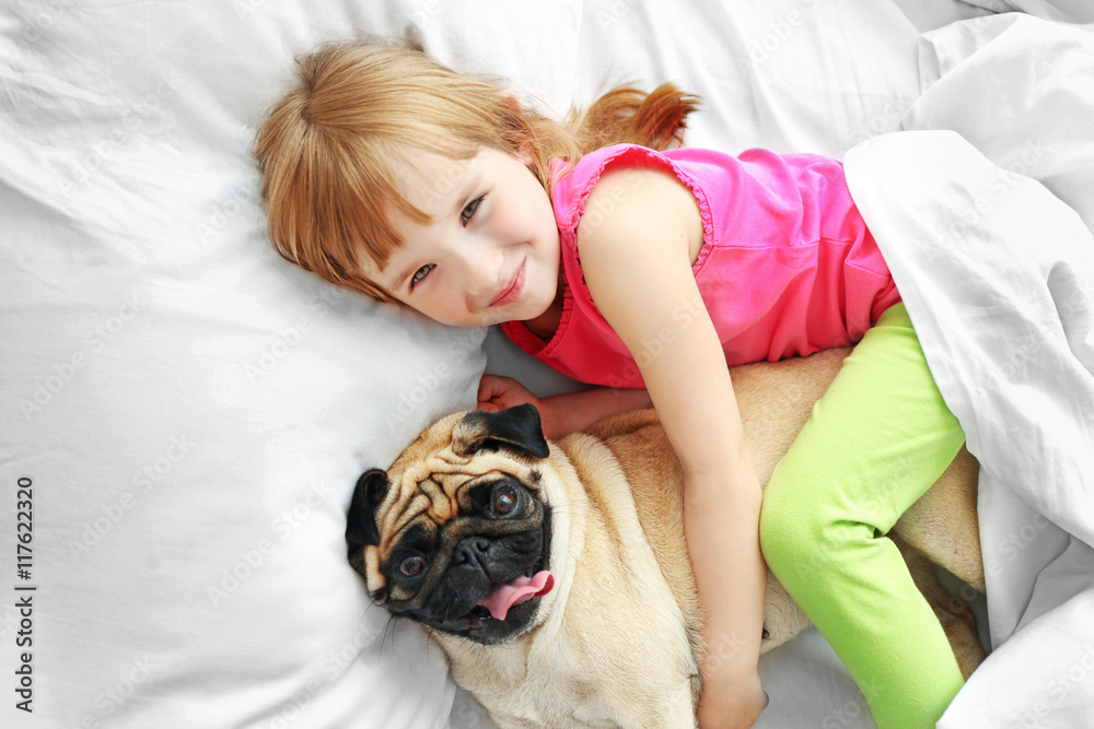 Beautiful girl and cute pug on bed Beautiful girl and cute pug on bed