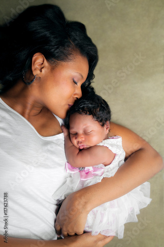 African American Mother Kissing Newborn Daughter