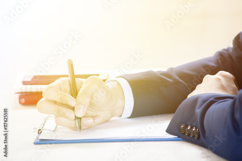 Closeup of Businessman writing on paper on notepad