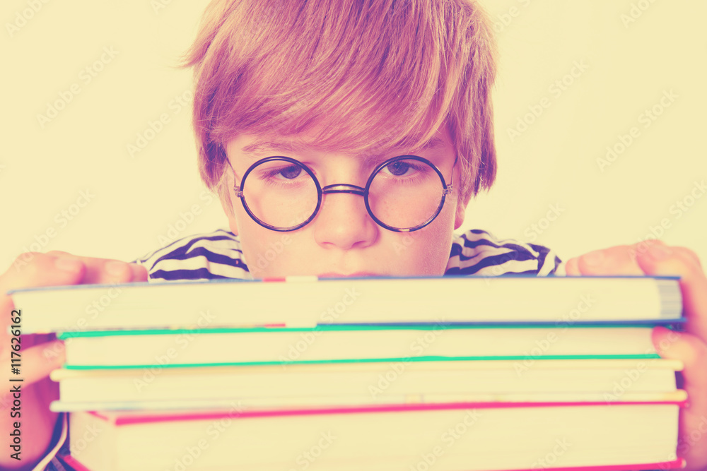 tired boy on a pile of books