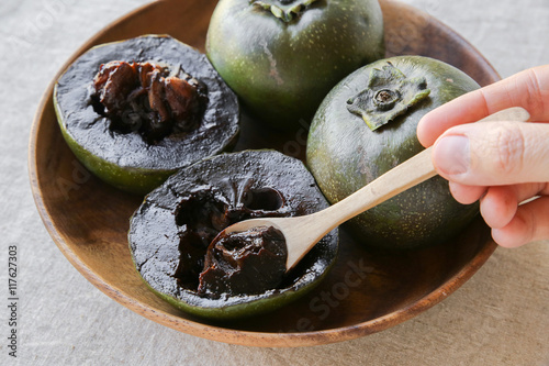 Black sapote chocolate pudding fruit in wooden plate