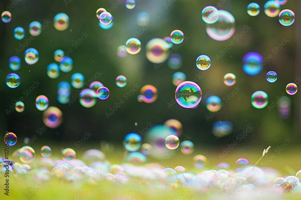 Rainbow bubbles on grass background. Abstract background.