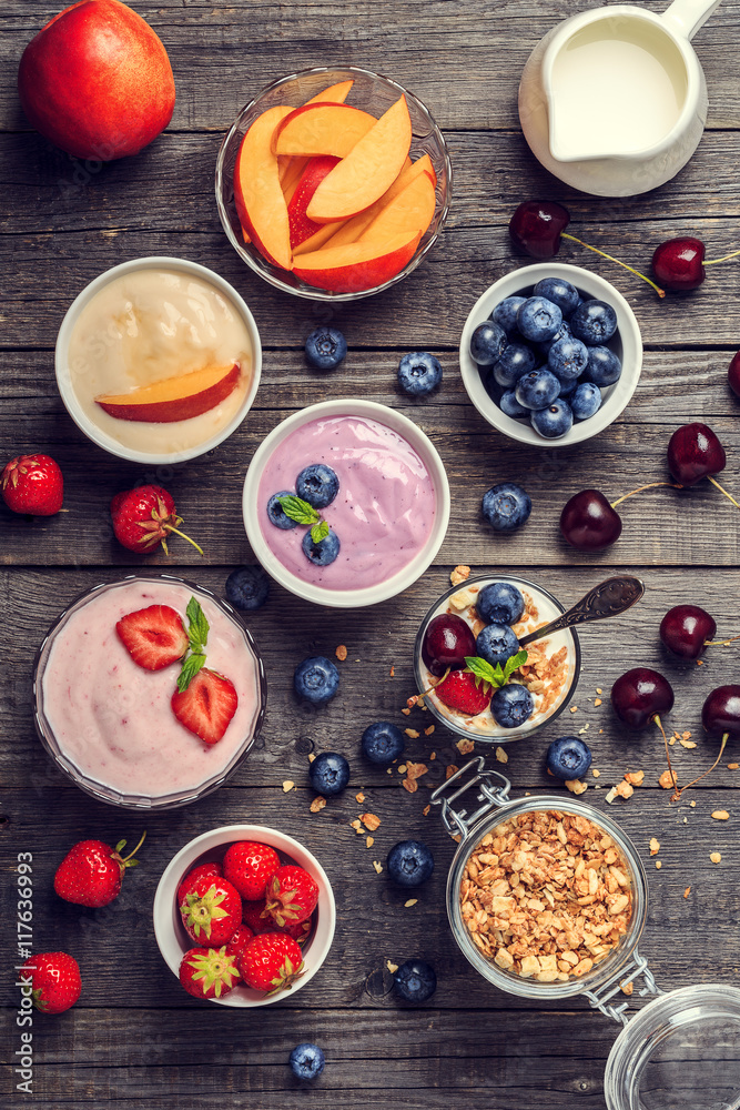 Homemade yogurt with fresh strawberry, blueberry, peach on a woo Homemade yogurt with fresh strawberry, blueberry, peach on a woo
