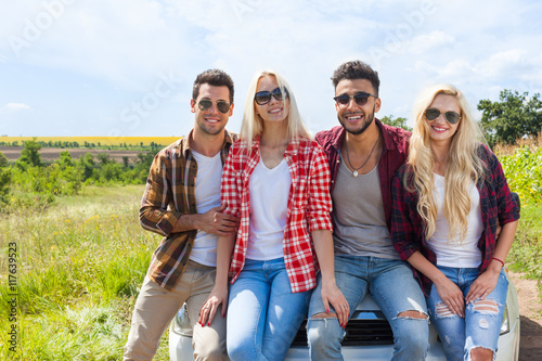 Friends sitting on car outdoor countryside people smile