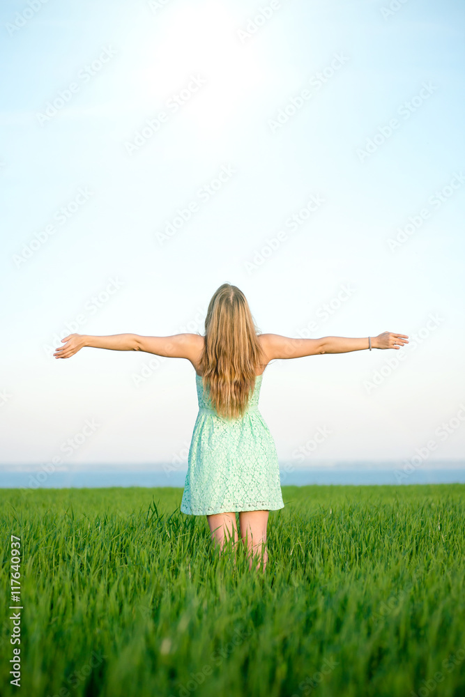 Happiness woman stay outdoor under sunlight of sunset. With raised hands at the sunrise time. Happiness woman stay outdoor under sunlight of sunset. With raised hands at the sunrise time.