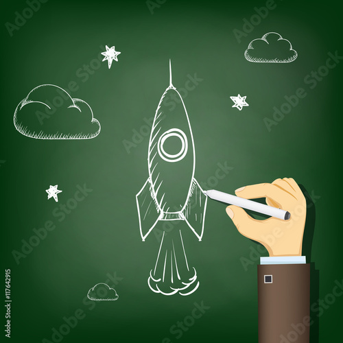Human hand drawing chalk on a blackboard a rocket. Startup and b