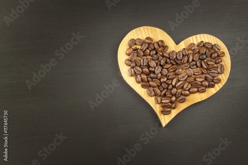 Sales of coffee. Coffee beans on wooden background.
