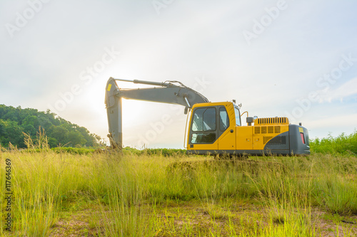 Excavator machine in a park with sunlight background photo