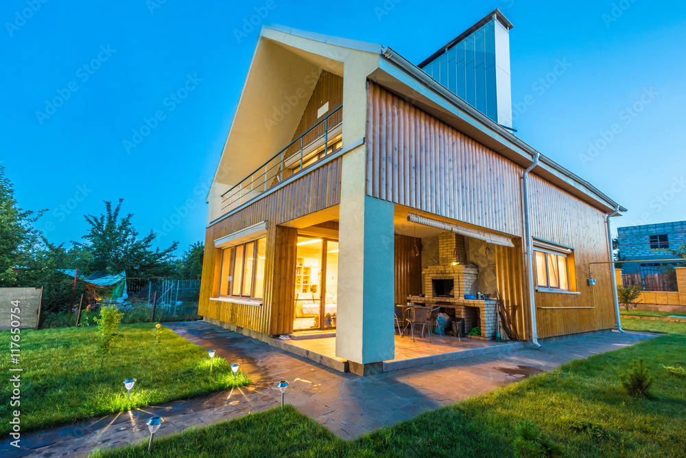 Obraz premium Wooden house with meadow in front of it