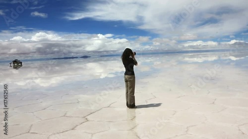 Woman taking pictures in the middle of the lake Salar de Uyuni, Bolivia