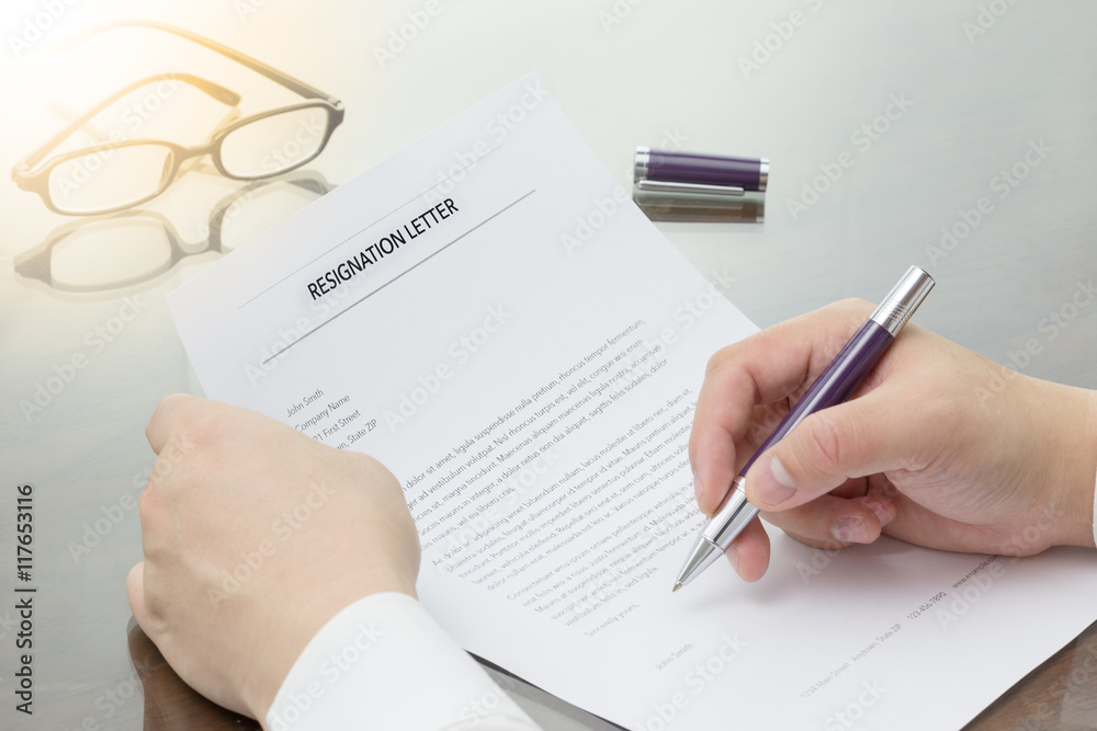 Businessman review his resignation letter on his desk before sending to his boss to quit his job. Businessman review his resignation letter on his desk before sending to his boss to quit his job.