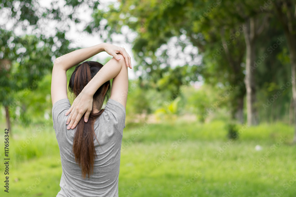 Young healthy woman practicing yoga in the park.